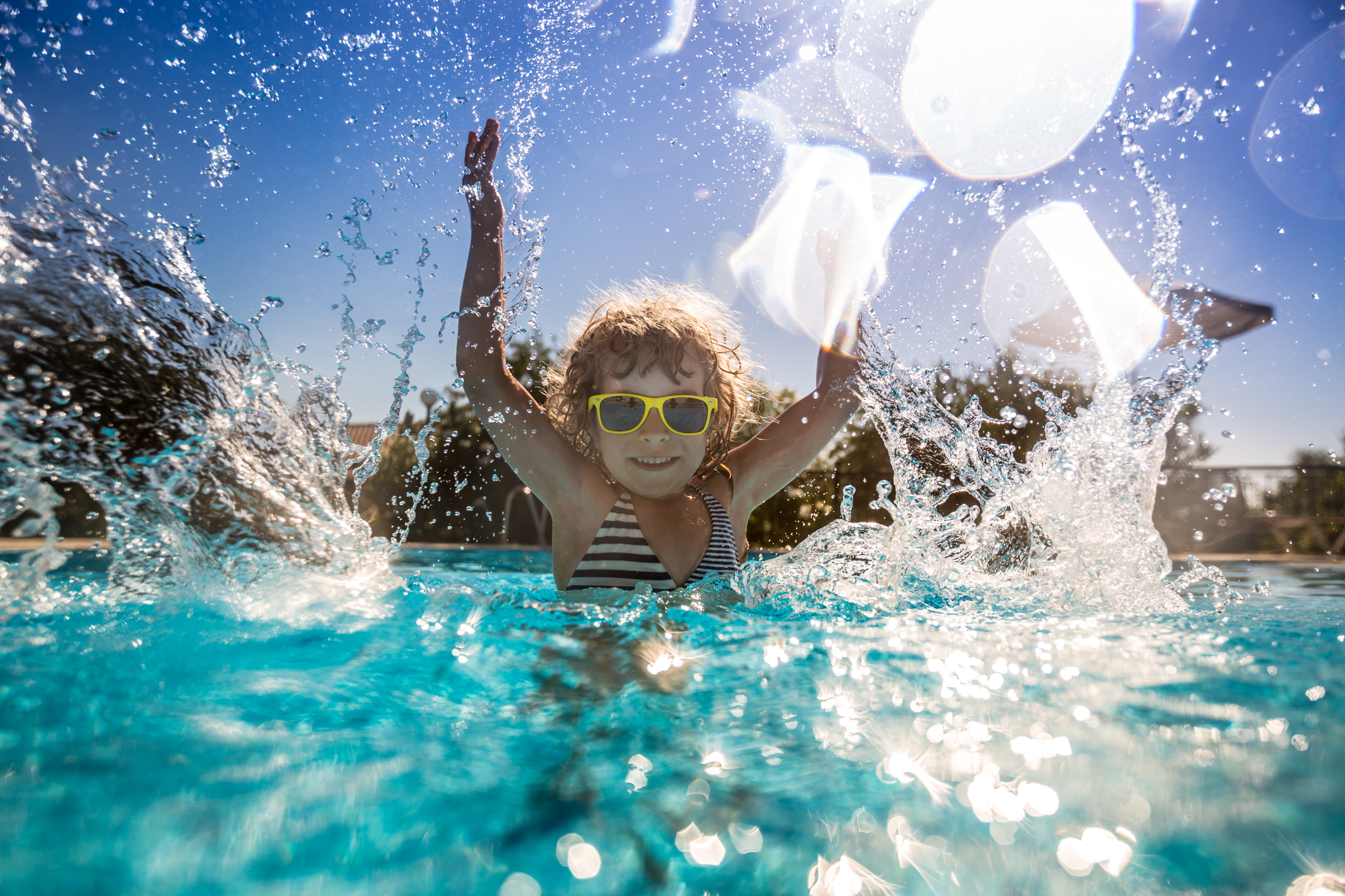 Child playing in bright pool water
